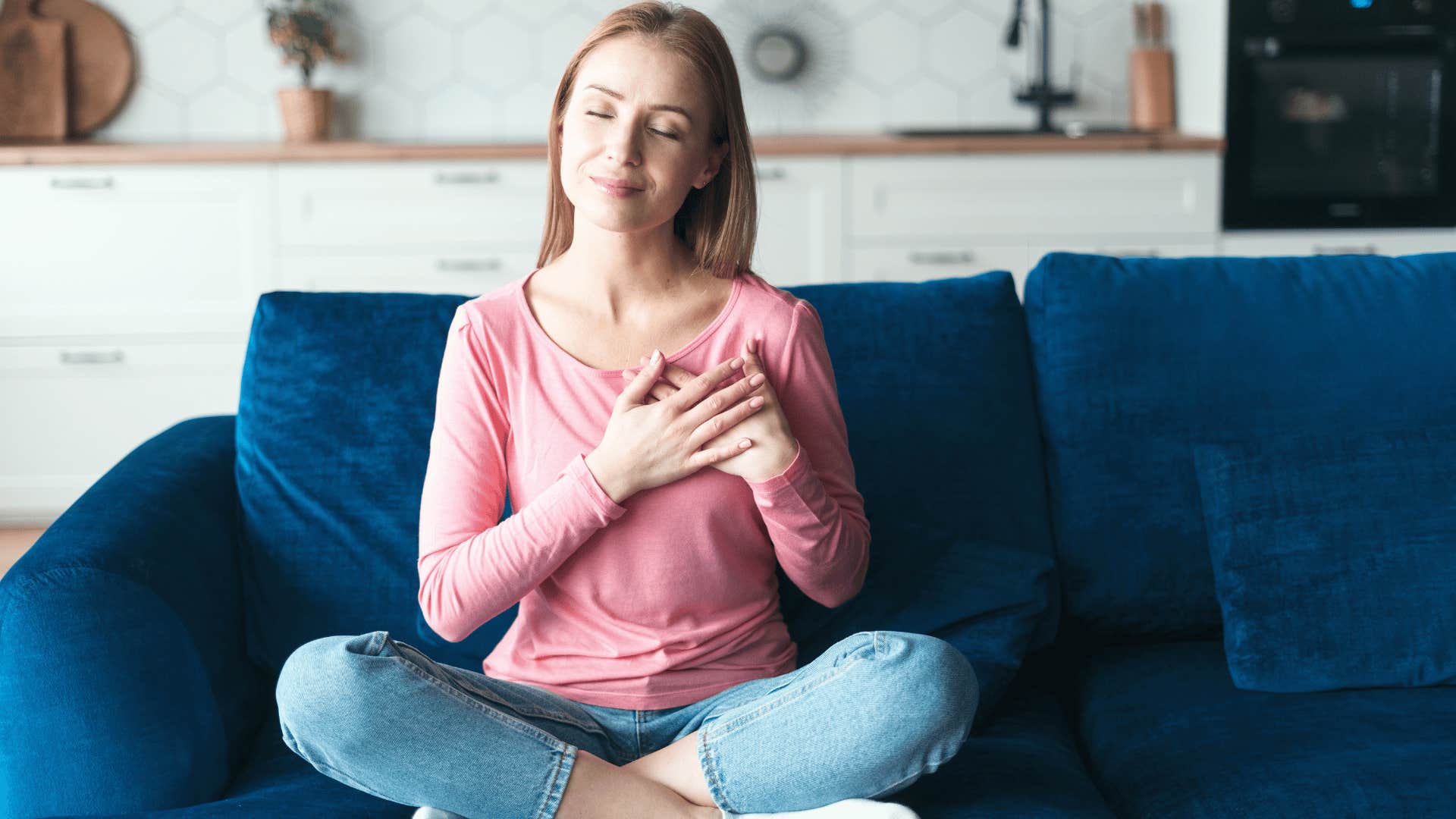 woman sitting with her hand to her heart