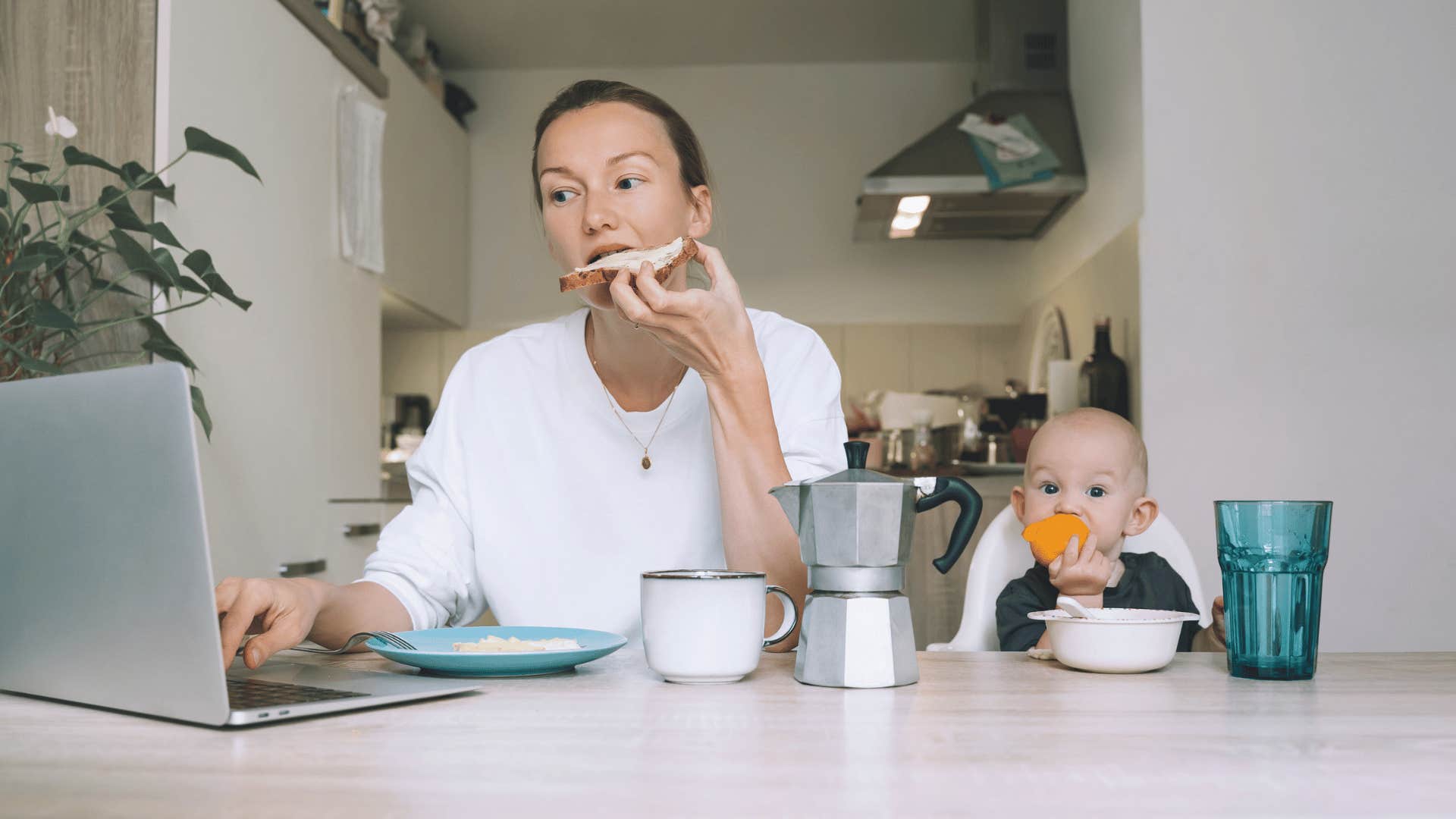 woman working on laptop while eating