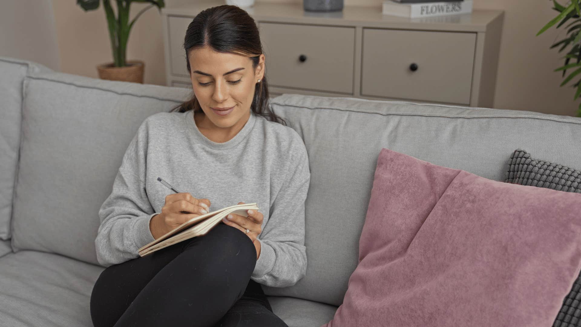 woman writing on couch