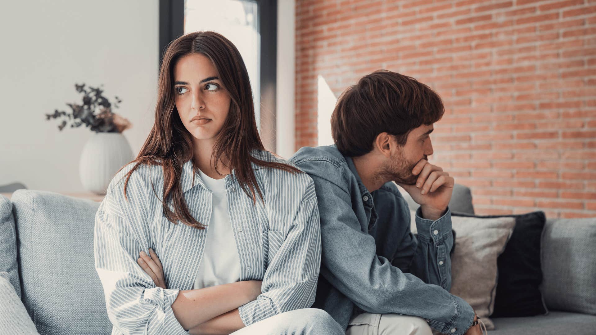 couple ignoring each other on couch