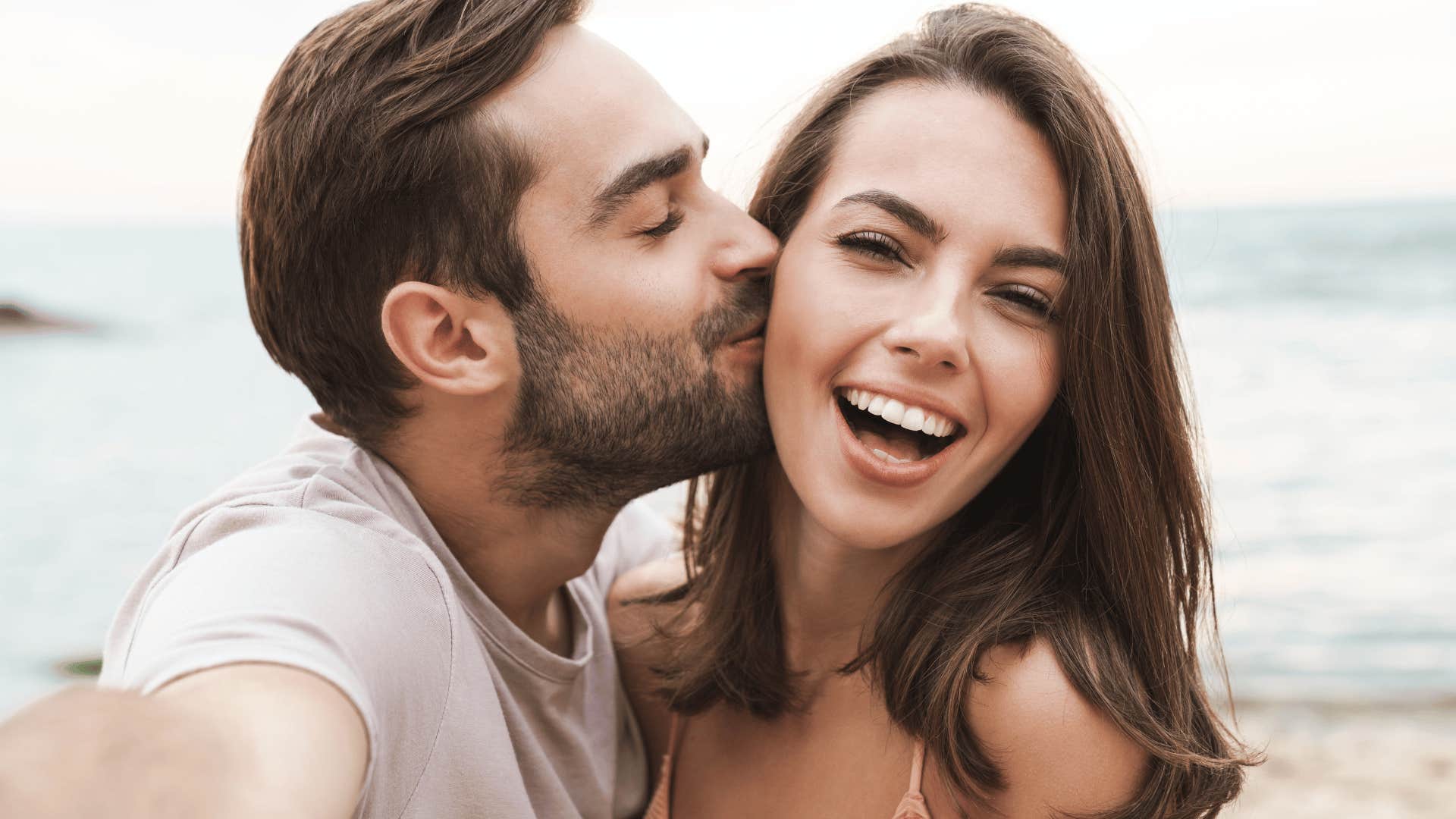 man kissing woman on the cheek