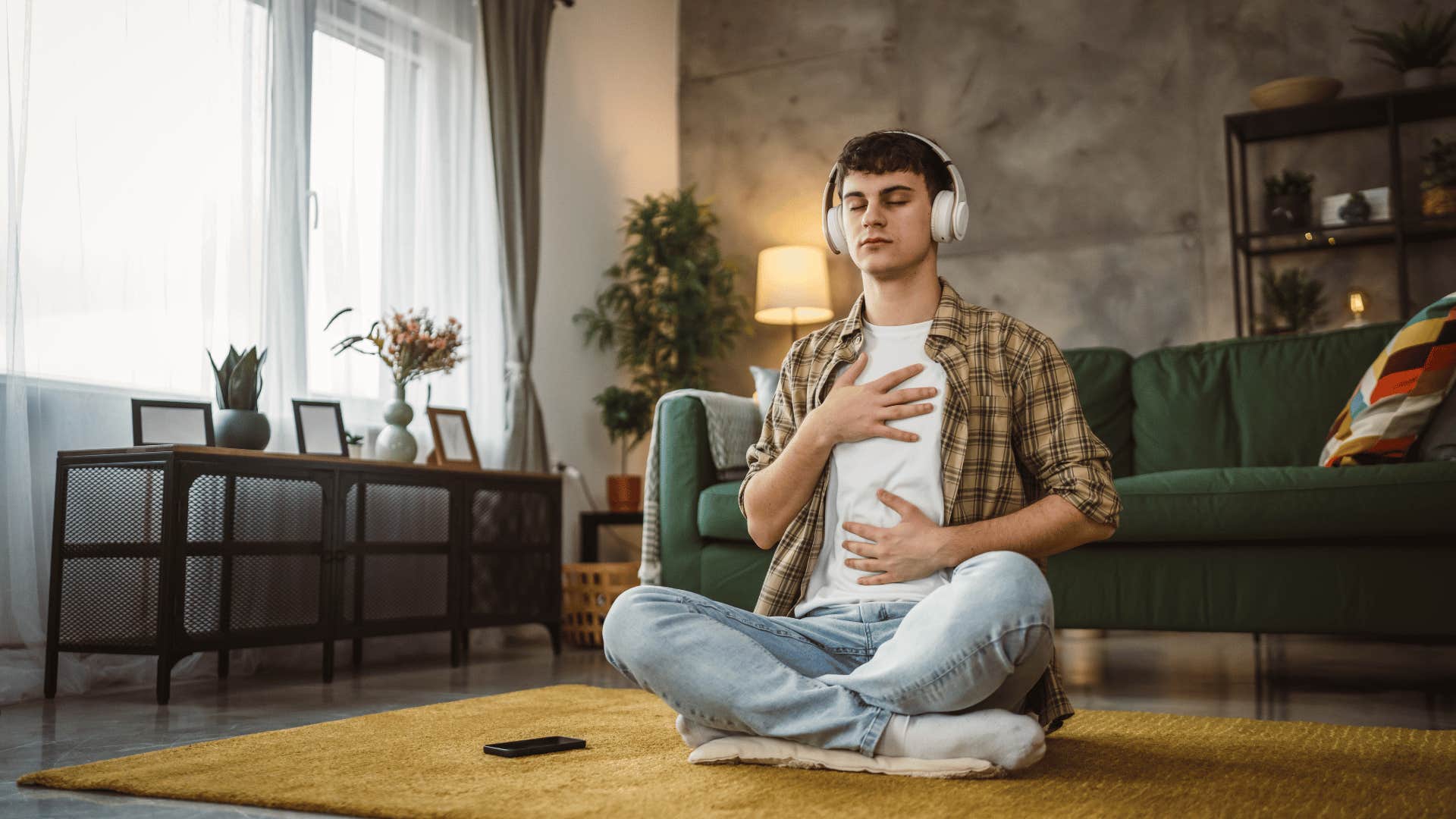 man sitting on ground and listening to music