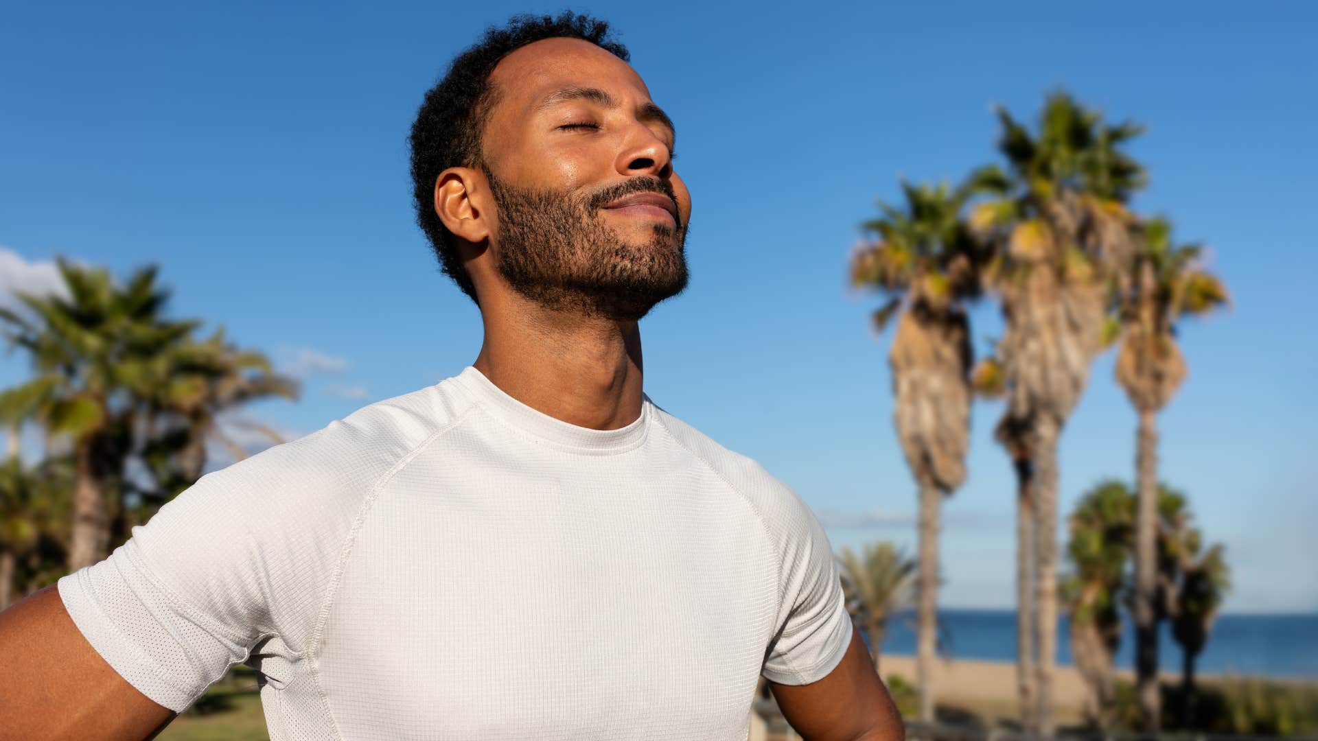 patient man standing outside with his eyes closed