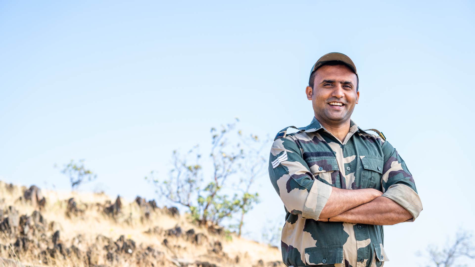 respectable, confident smiling man standing with arms crossed