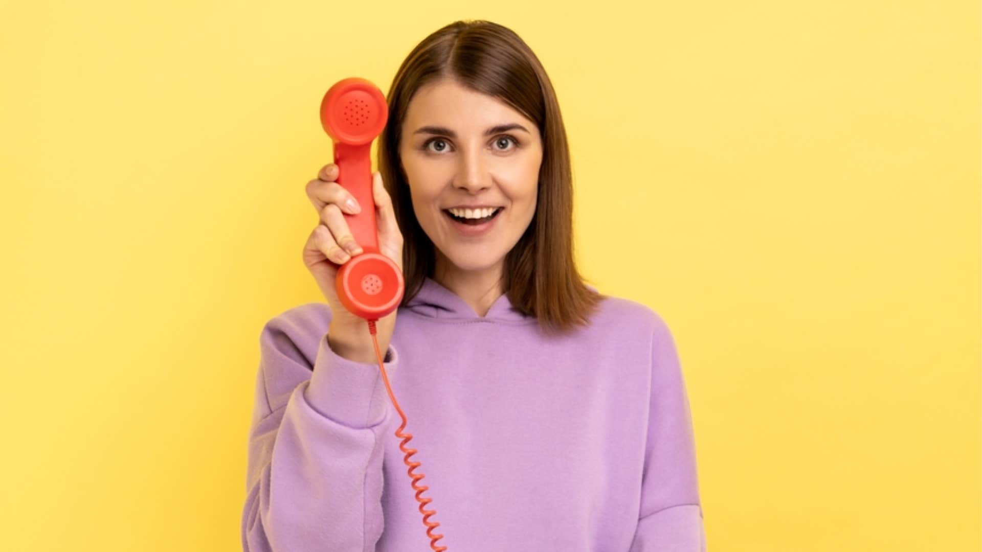 woman holding landline phone