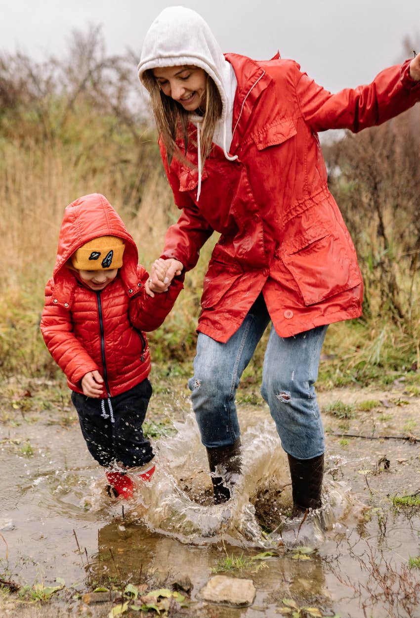 mom and son splashing in puddles