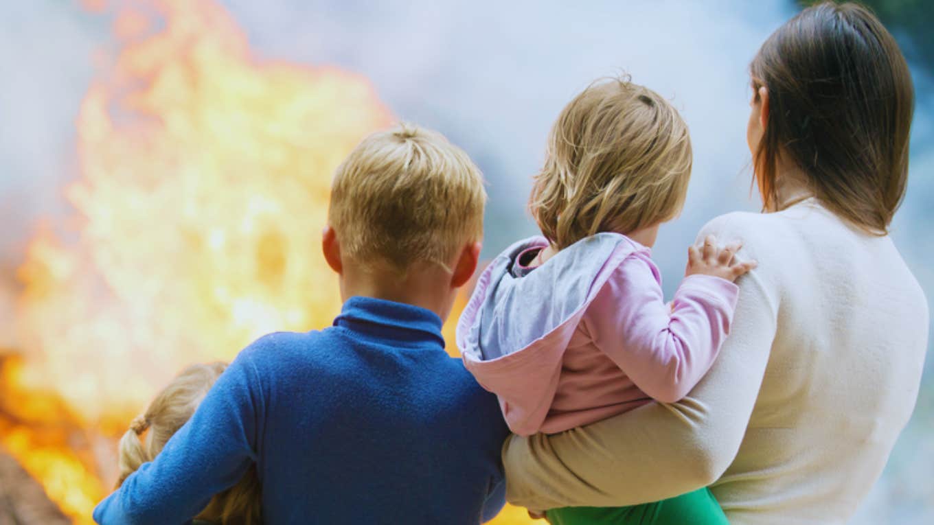 mom and children watching house burn