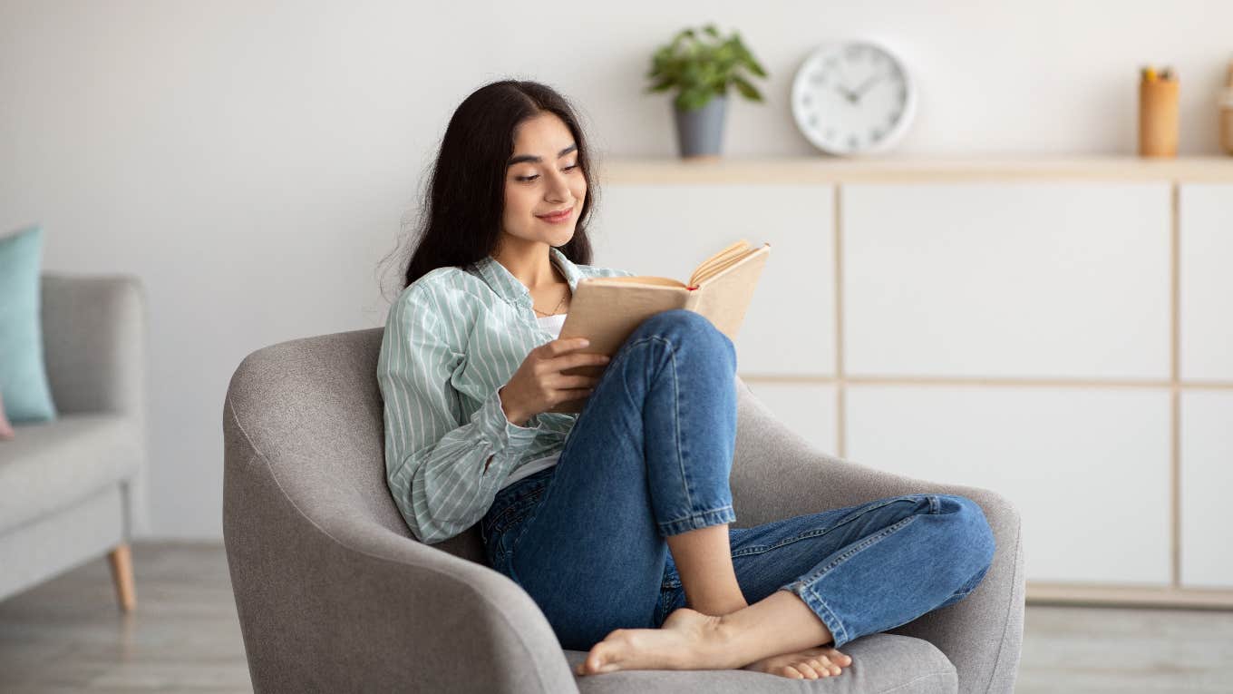 woman relaxing in chair while reading