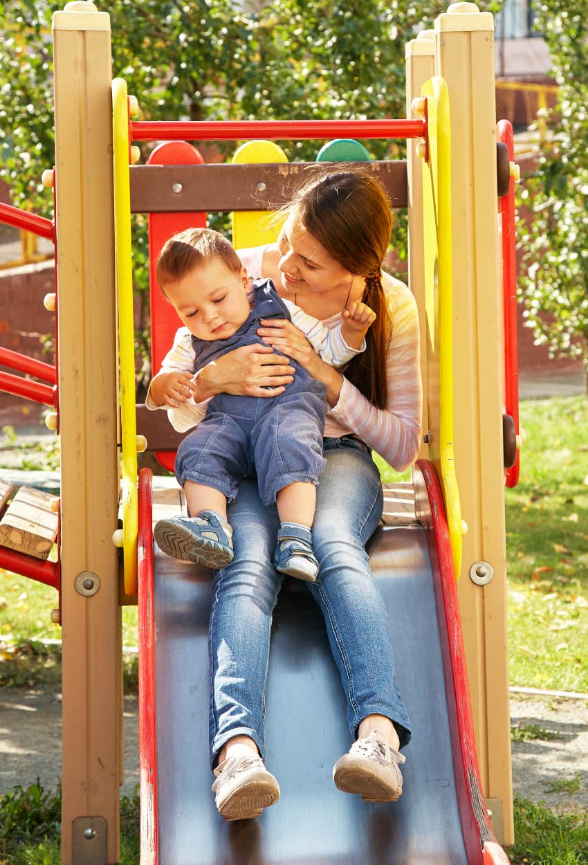 Nanny with a child on a slide at the playground