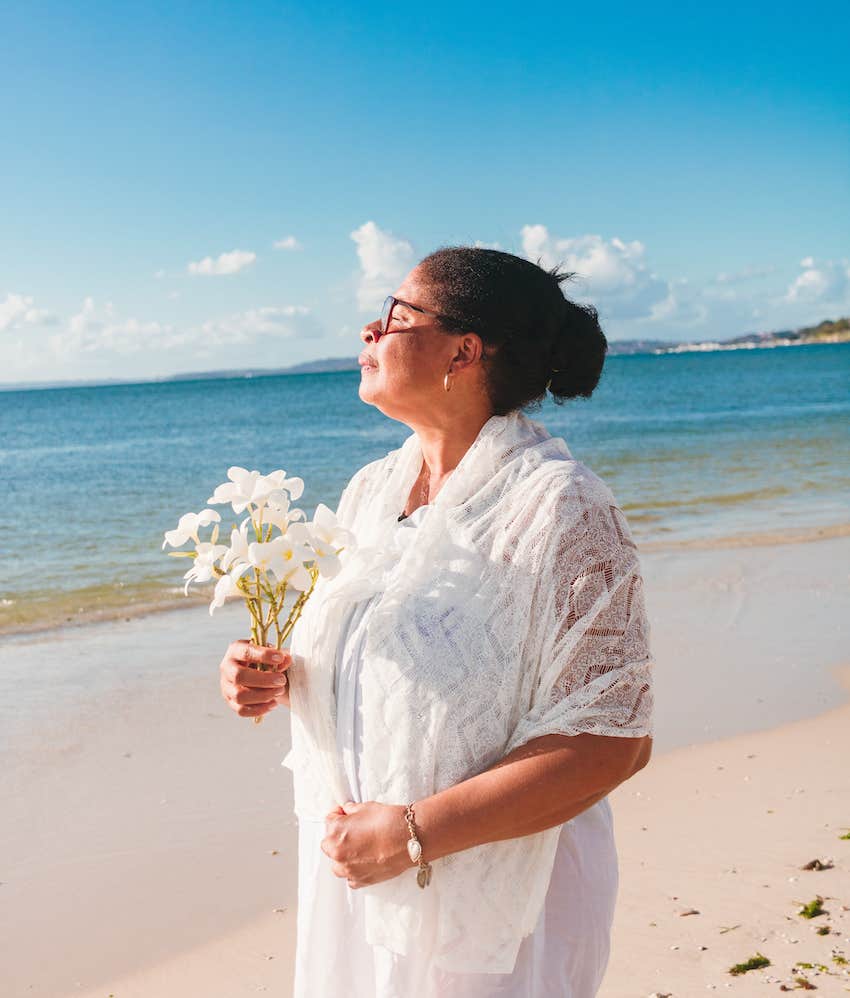 Woman on beach holding flowers