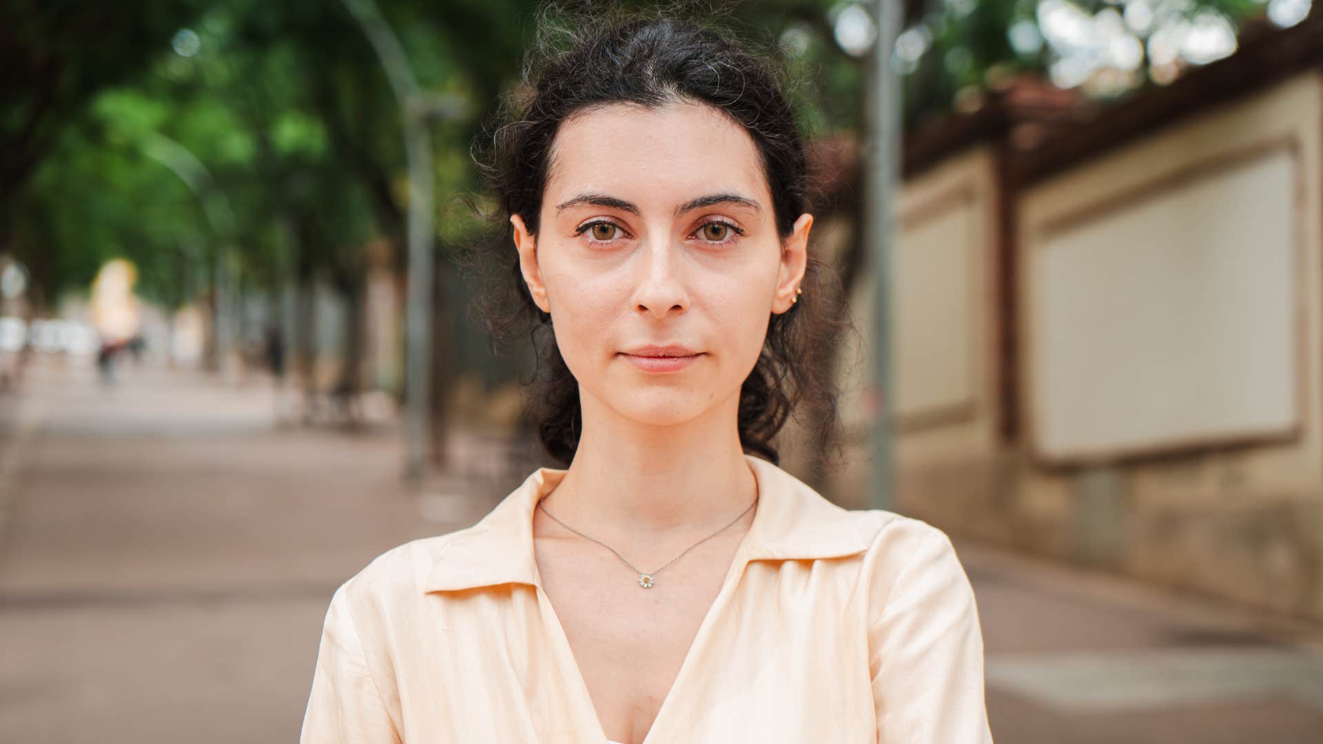 Young woman looking pensive at camera, standing on an empty street