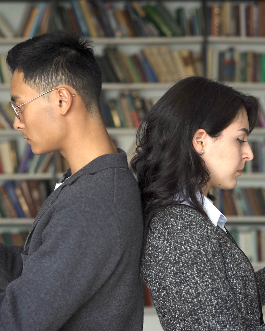 Unhappy couple stand back to back because heinous stuff was done