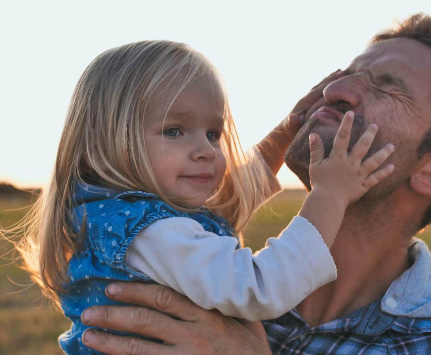 Little daughter plays with father s face