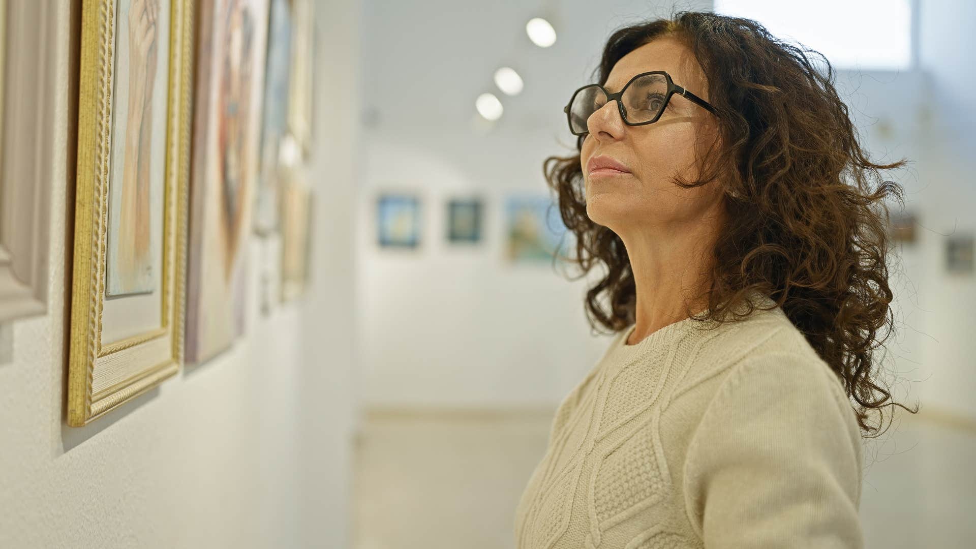 Woman admiring a piece of art in a gallery.