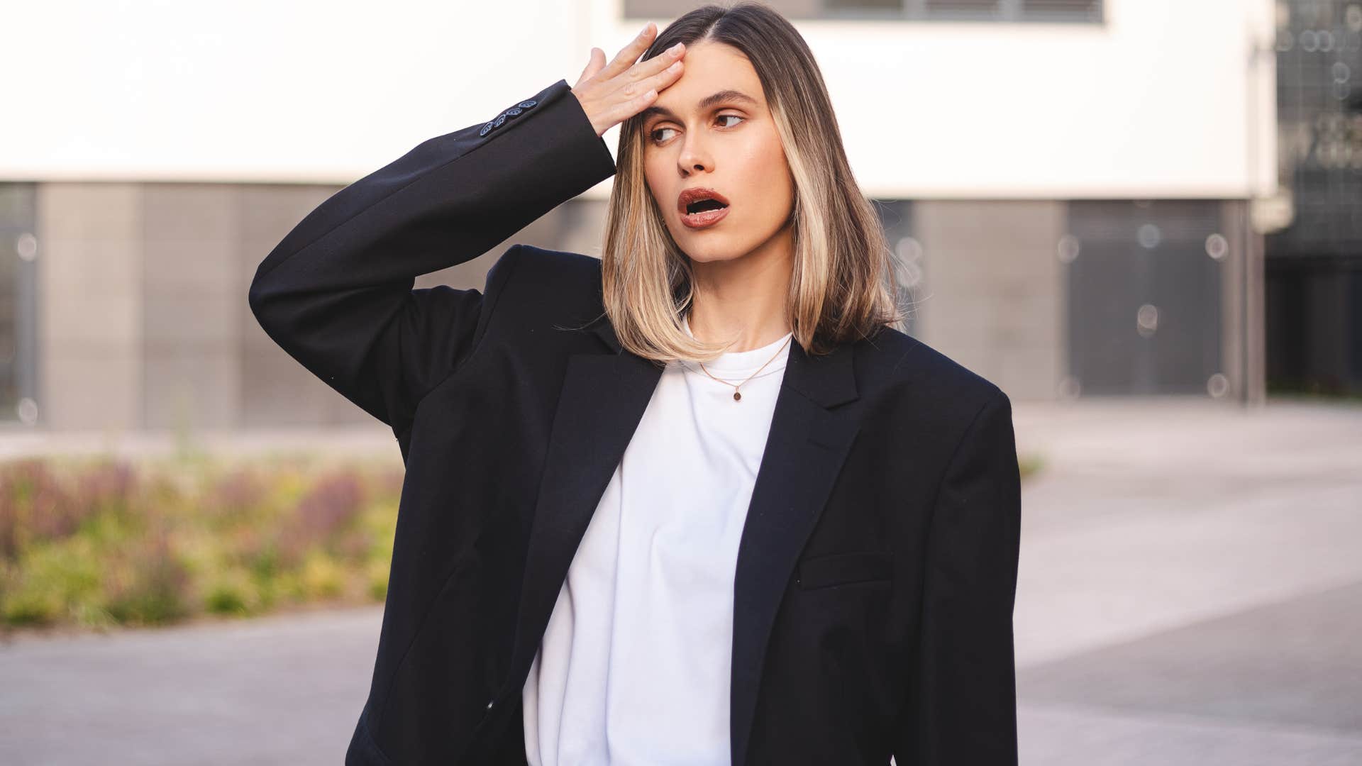 Woman looking confused and holding her head.