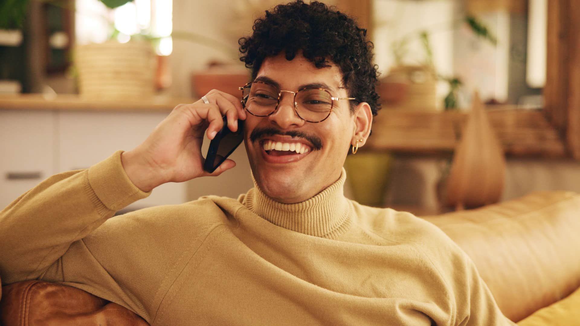 Man smiling and talking to someone on the phone.