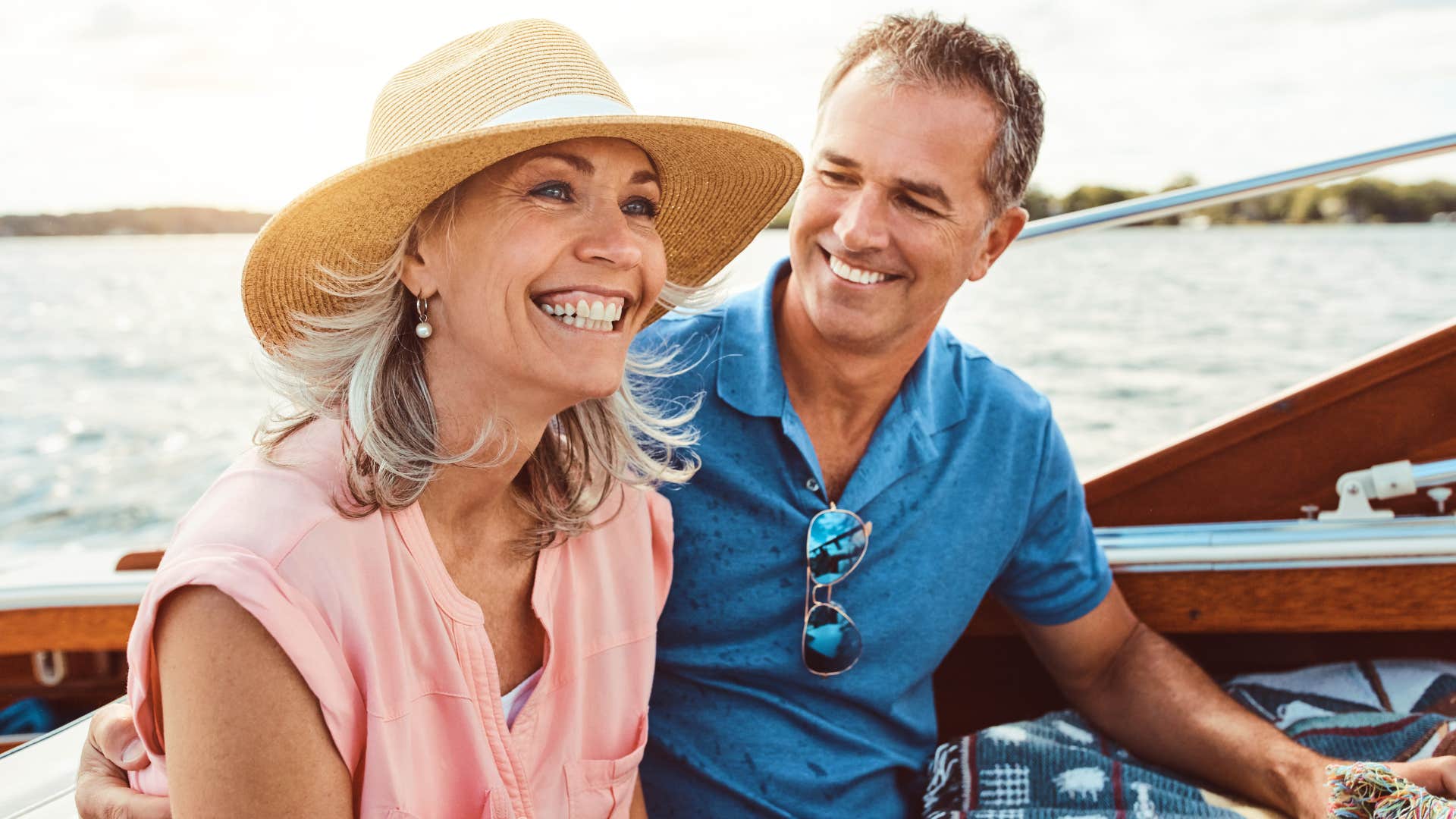 Older couple smiling and sitting together on a boat.