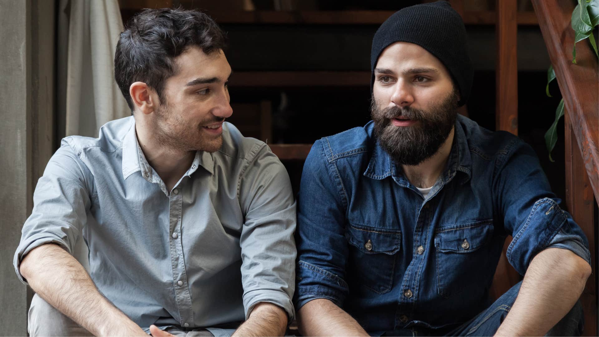 Two men smiling and talking together.