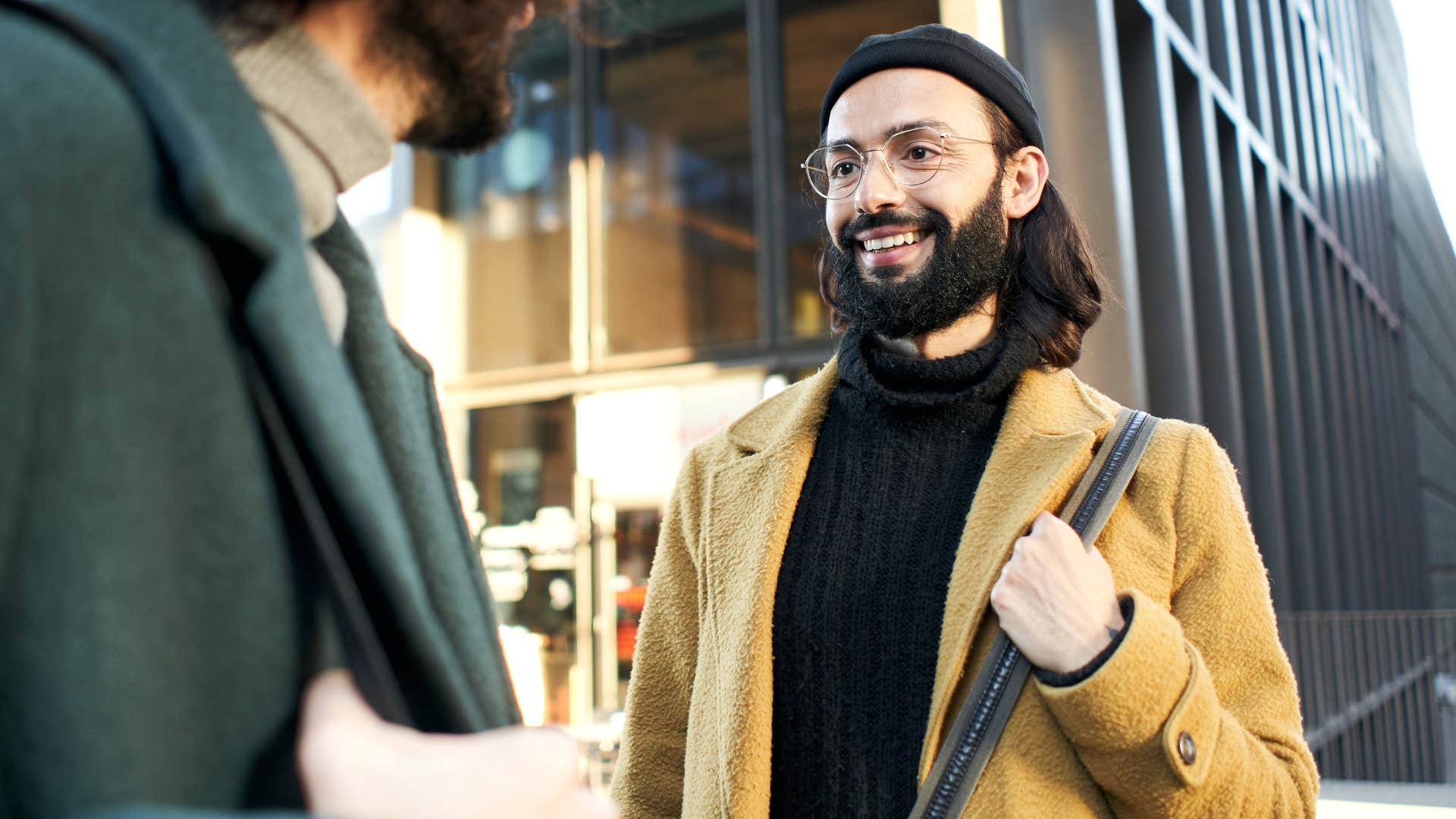 Man smiling and talking to his partner outside.