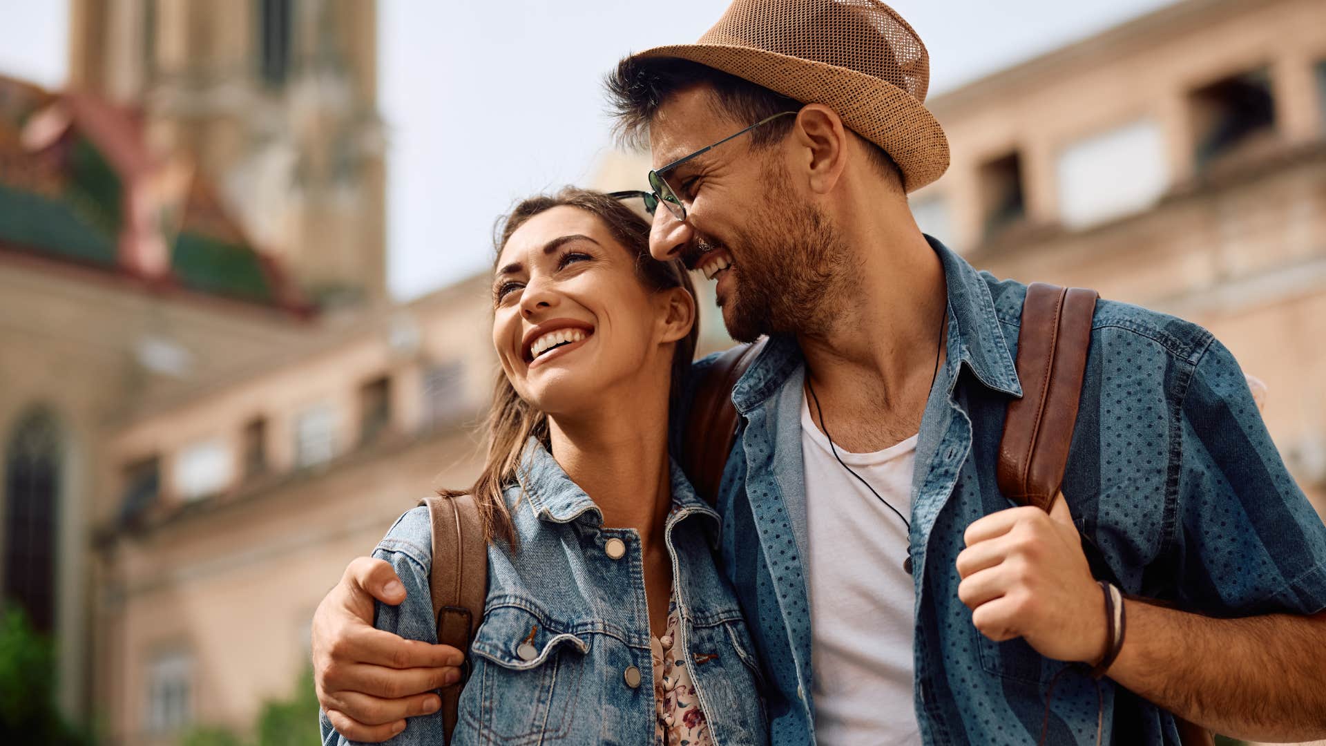 Couple smiling and hugging each other in public.