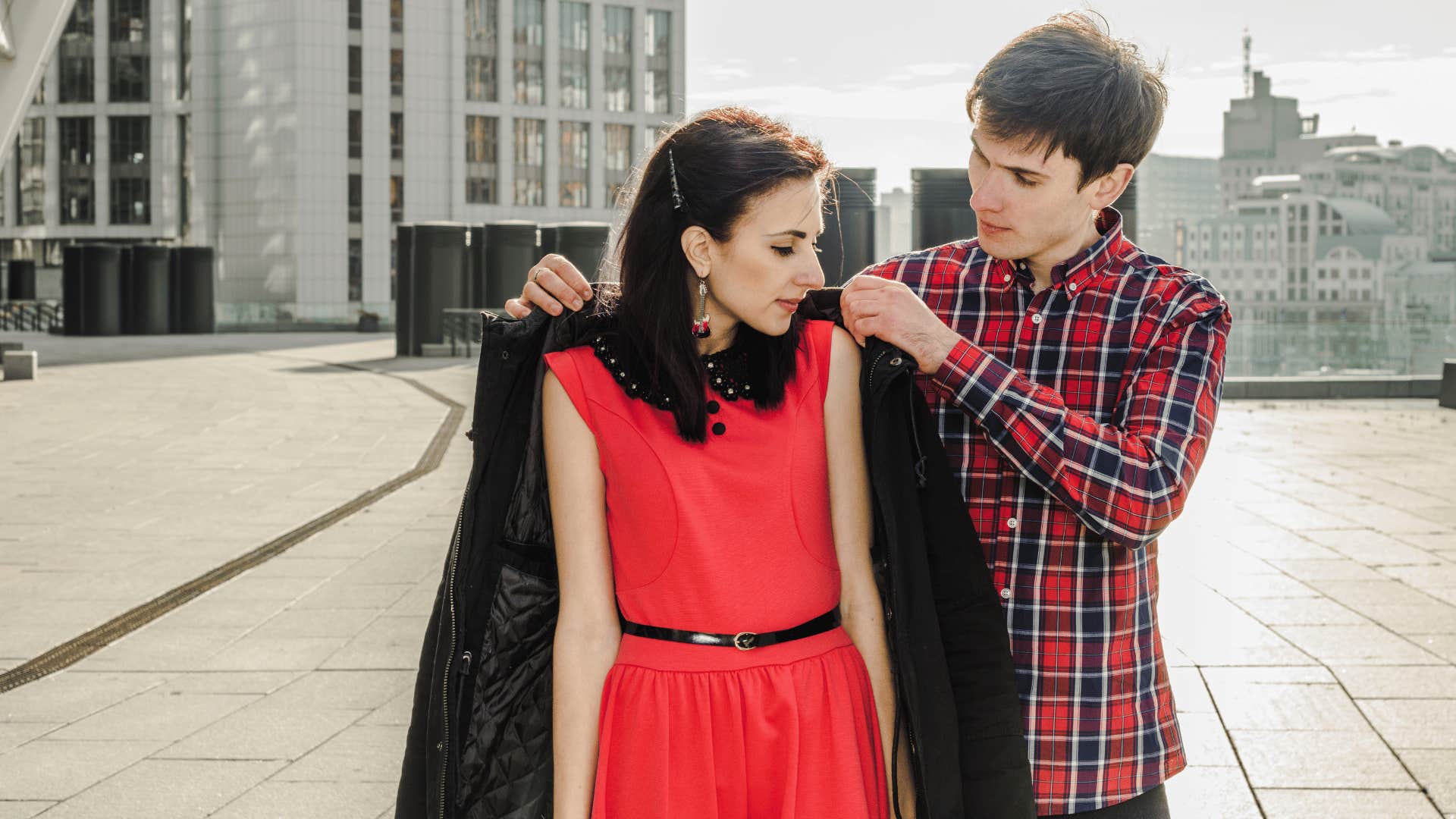 man giving woman jacket