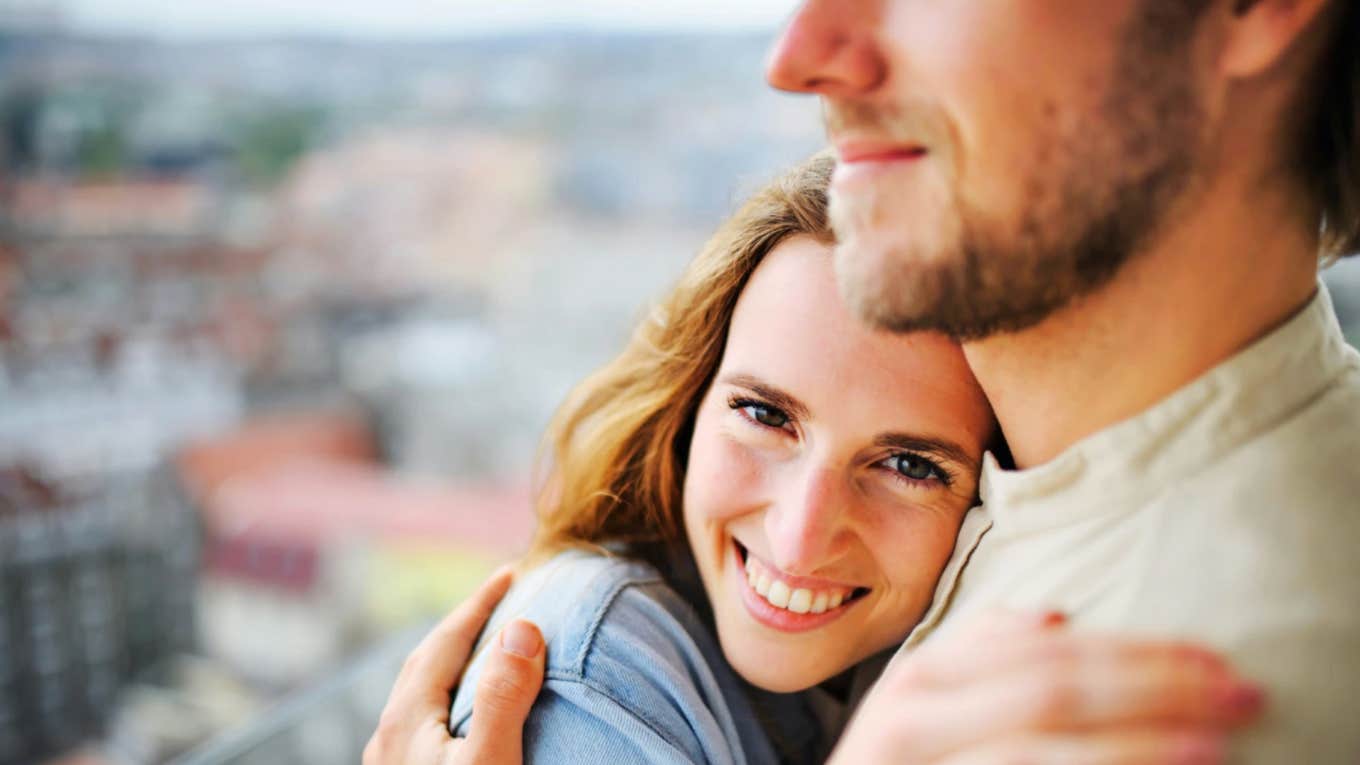 Woman hugging man, smiling outdoors opening up emotionally in a relationship 