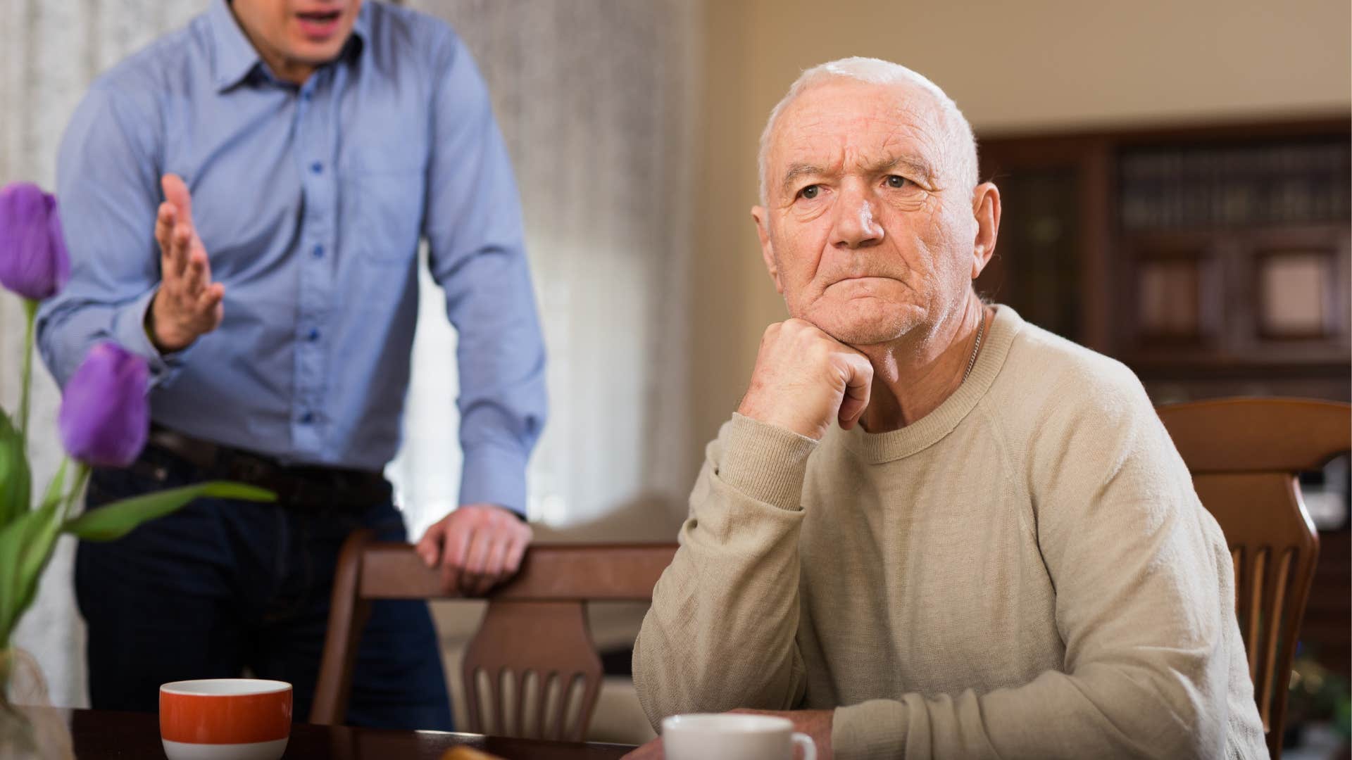 Upset boomer man turning away from his adult son