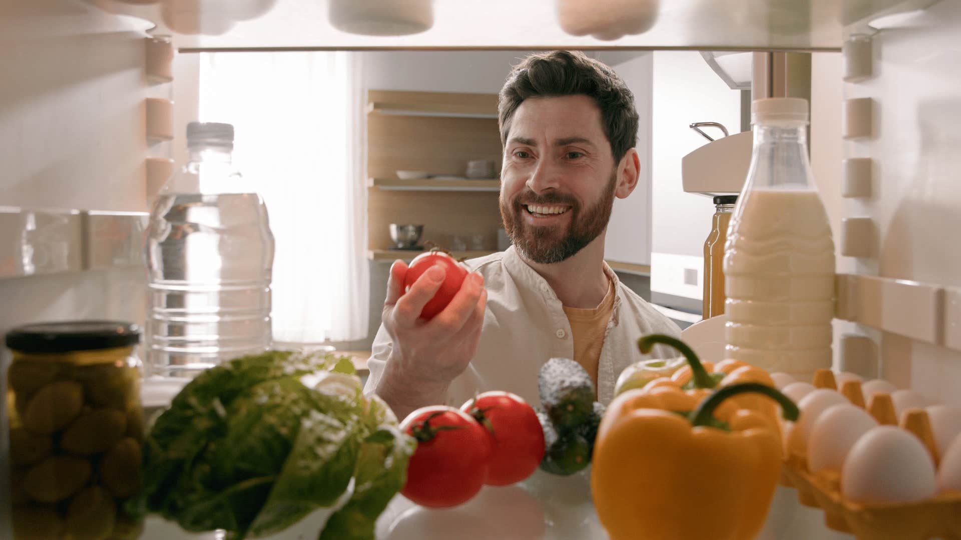 man looking in his refrigerator 