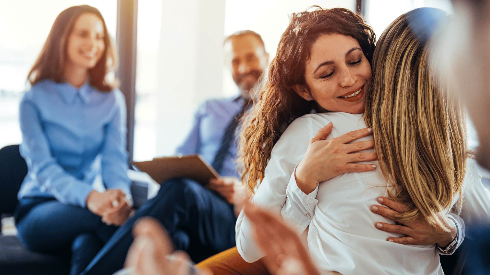 woman hugging another woman in a group