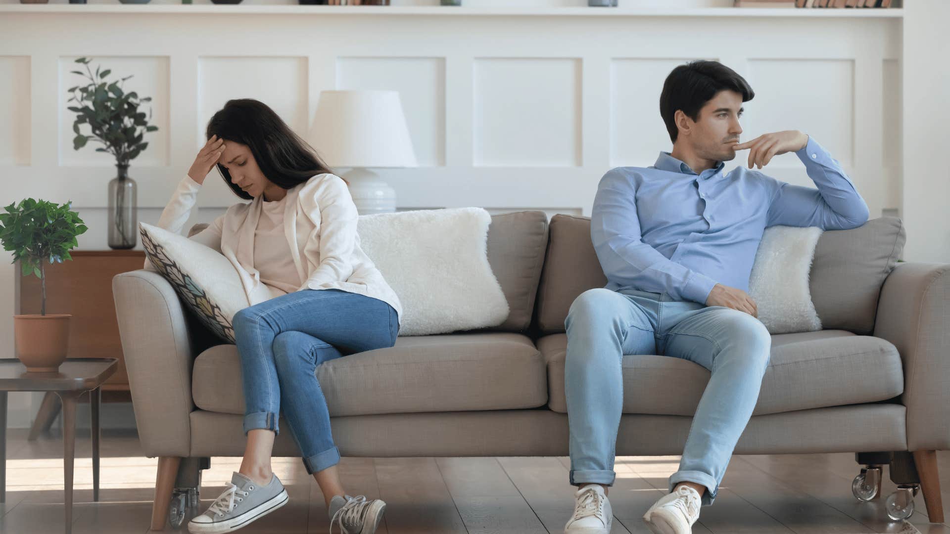 couple sitting far away from each other on couch