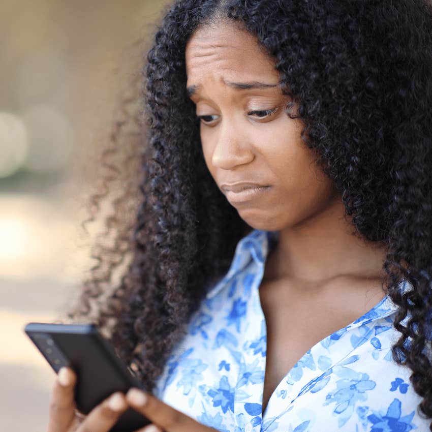 Perplexed woman looks at mobile phone