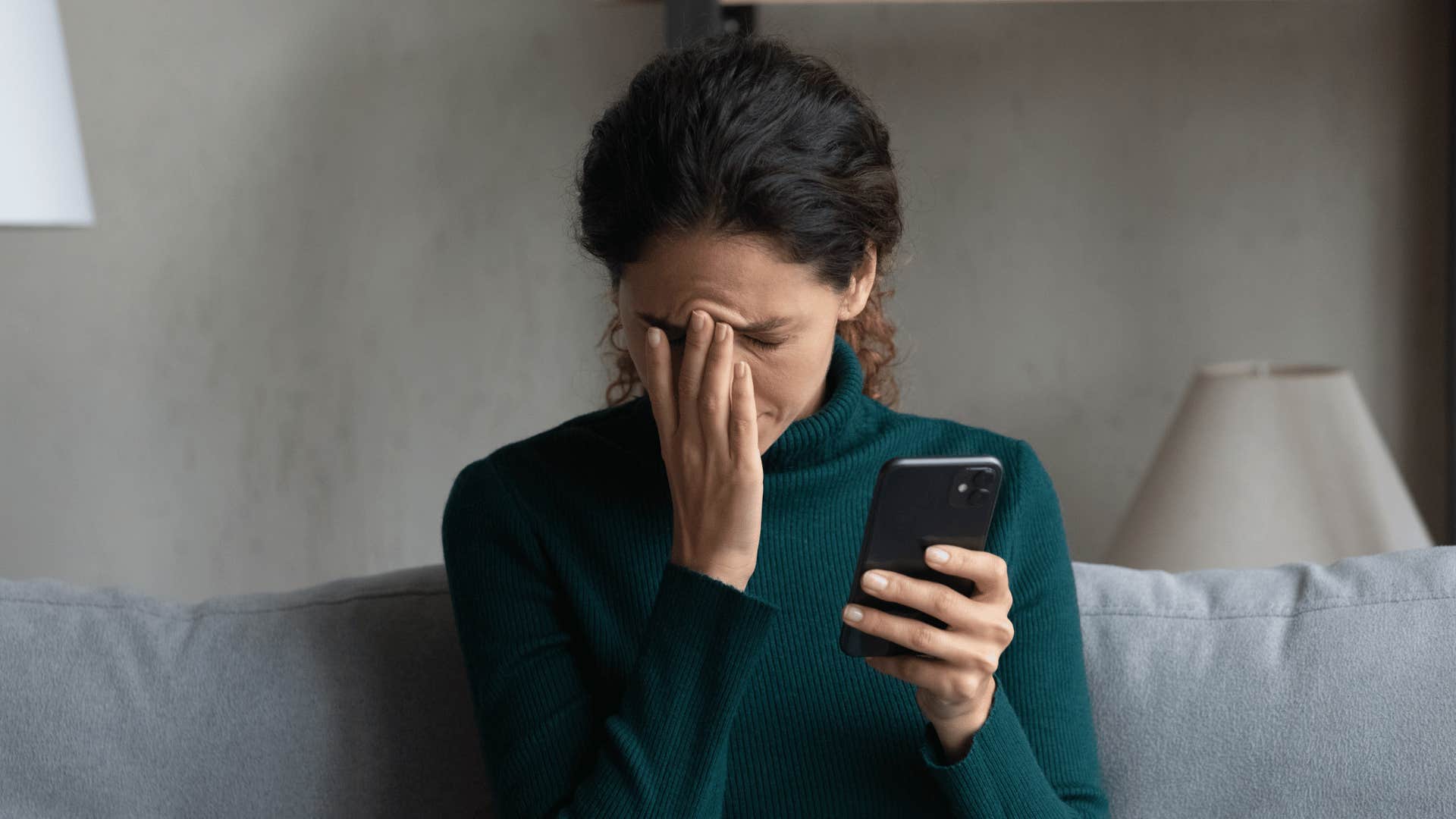 woman born on 1, 7, 11, 13, 24, 26, 28, 31 looking upset while holding phone with no time for nonsense