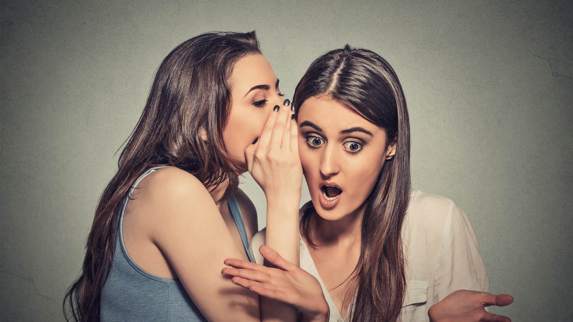 woman telling another woman a secret