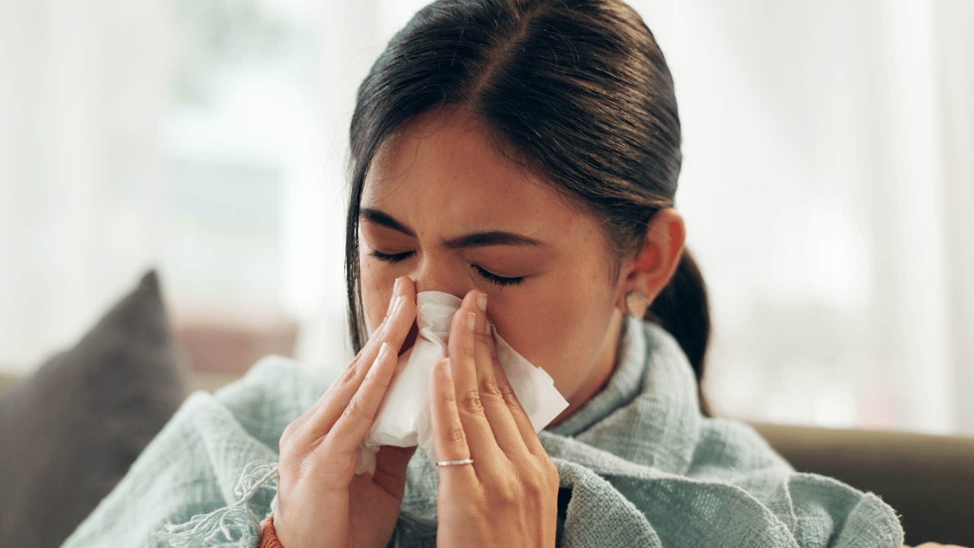 woman blowing nose sick not taking good care of self