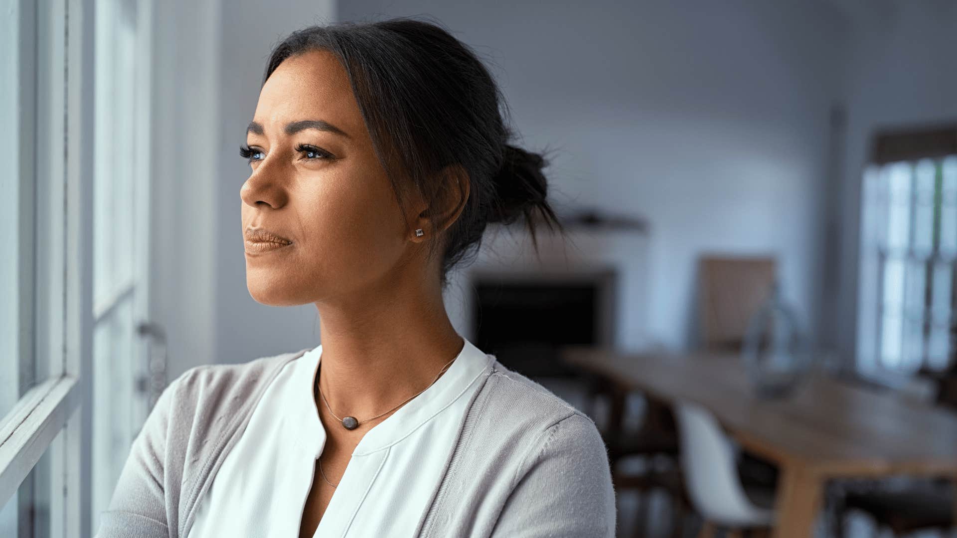 woman thinking and looking outside window