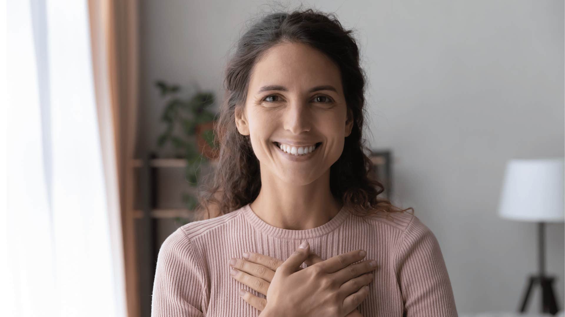 smiling woman with hand over heart