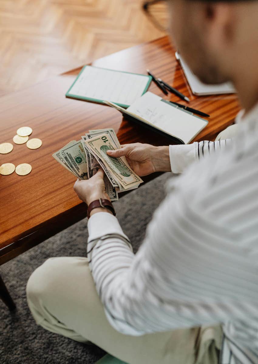 person sitting at a table counting money