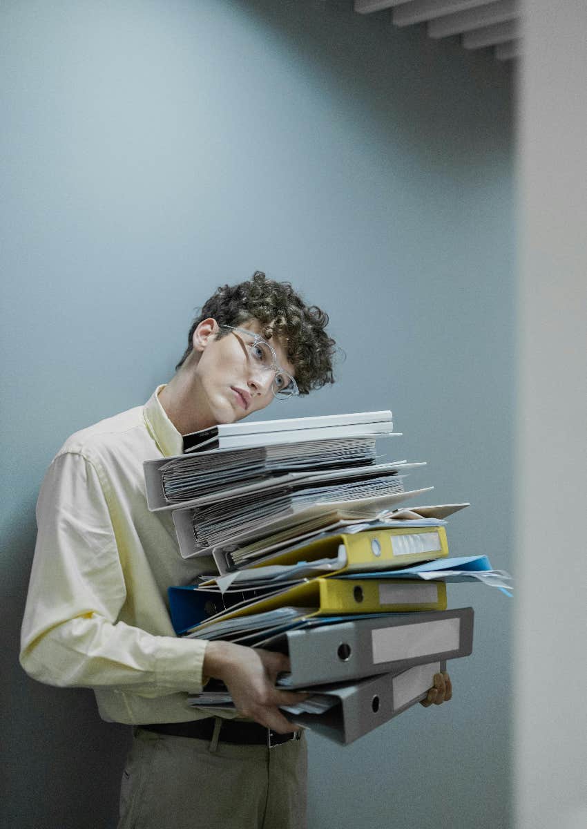 person in office holding stack of files