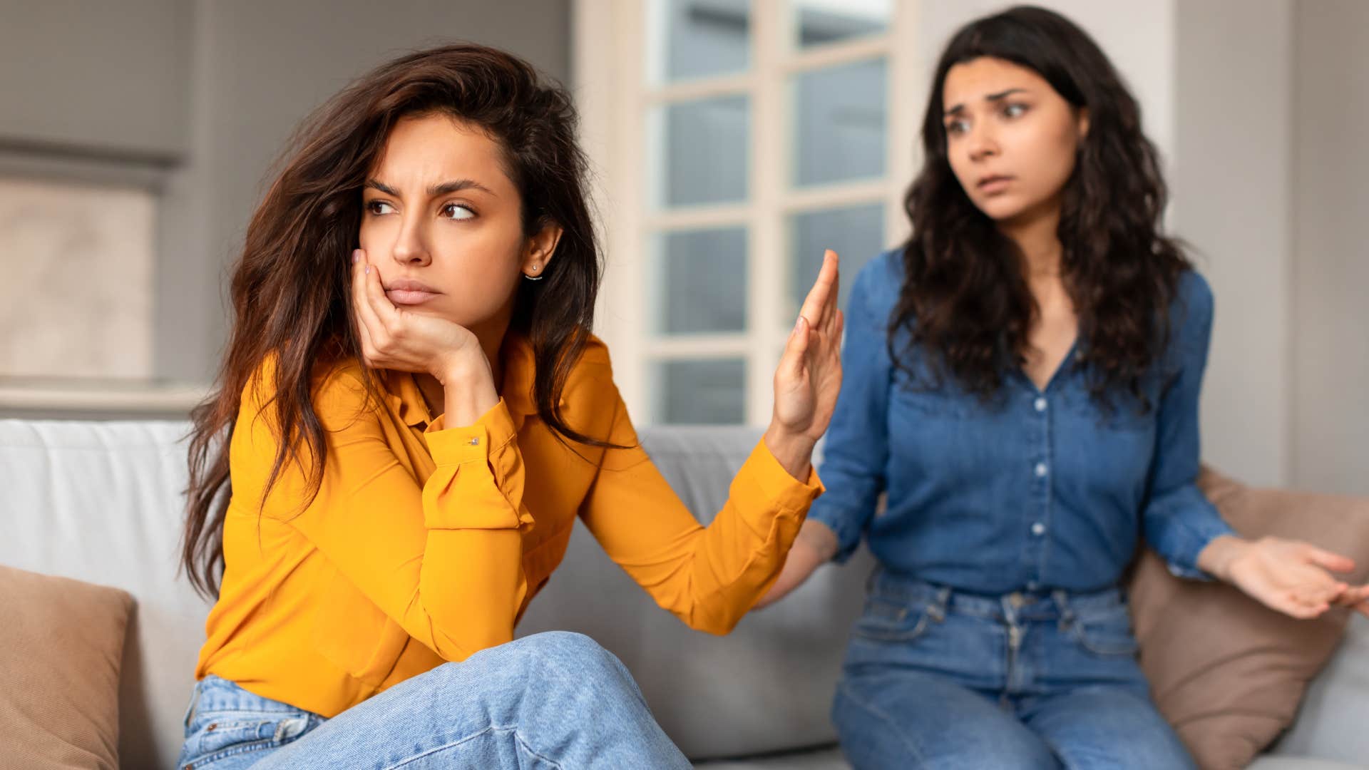 Woman holding her hand up in the face of her friend