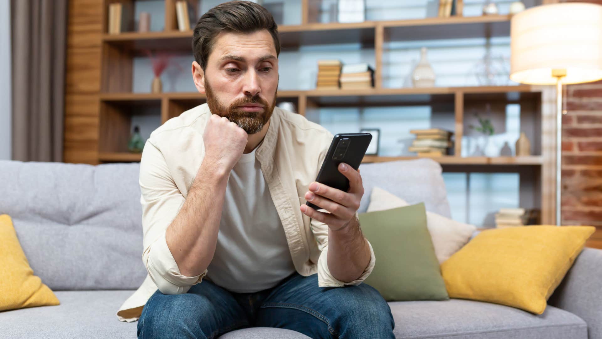 Man looking annoyed staring at his phone