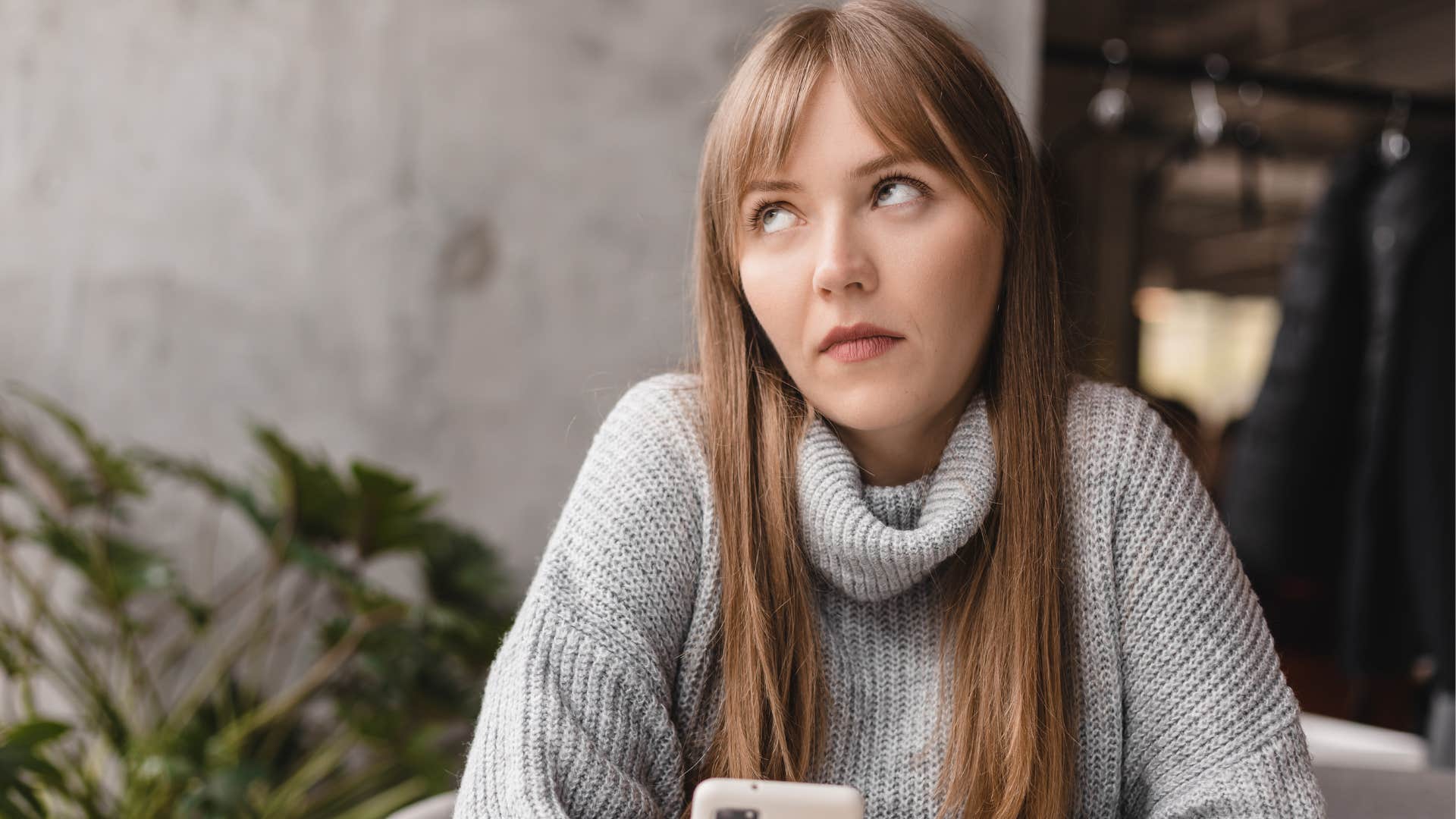 Woman rolling her eyes and looking at her phone