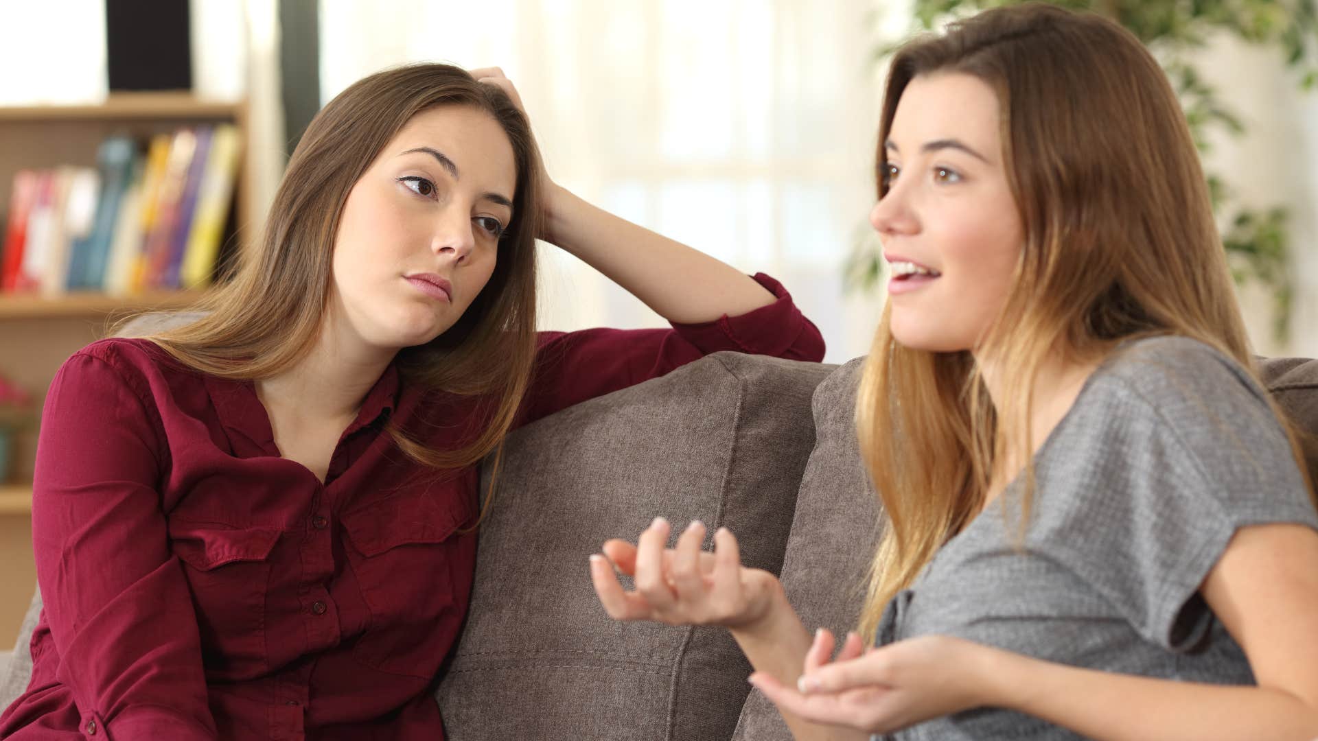 Woman looking annoyed staring at her friend speaking