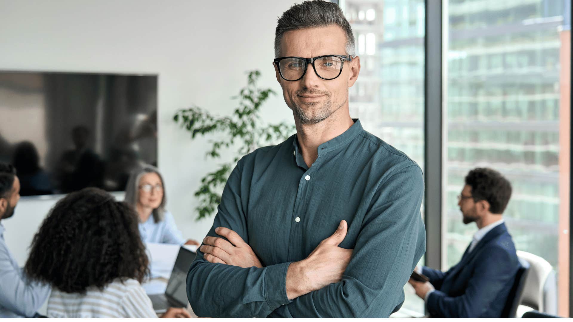 man crossing arms while in a meeting