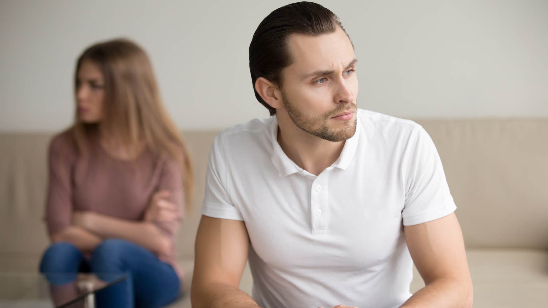 man angled away from woman on couch