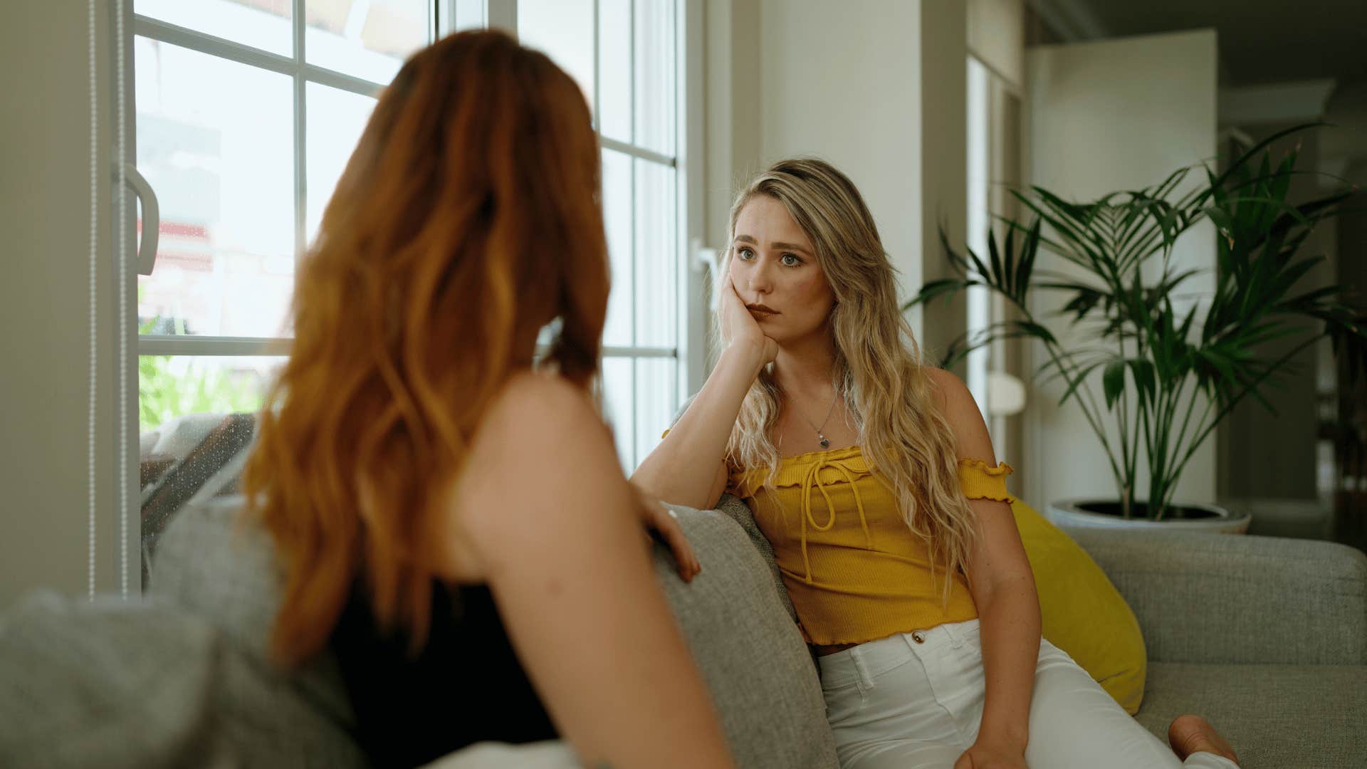 interested woman hearing out friend on couch