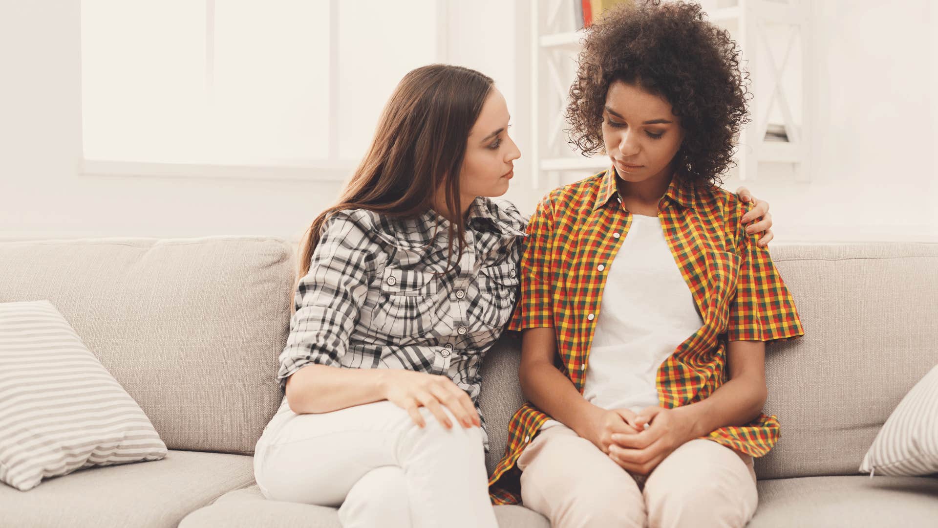 women on the couch having serious conversation