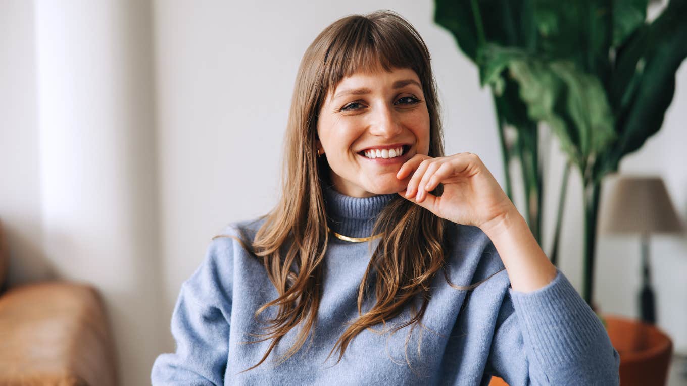 smiling confident woman in a blue sweater