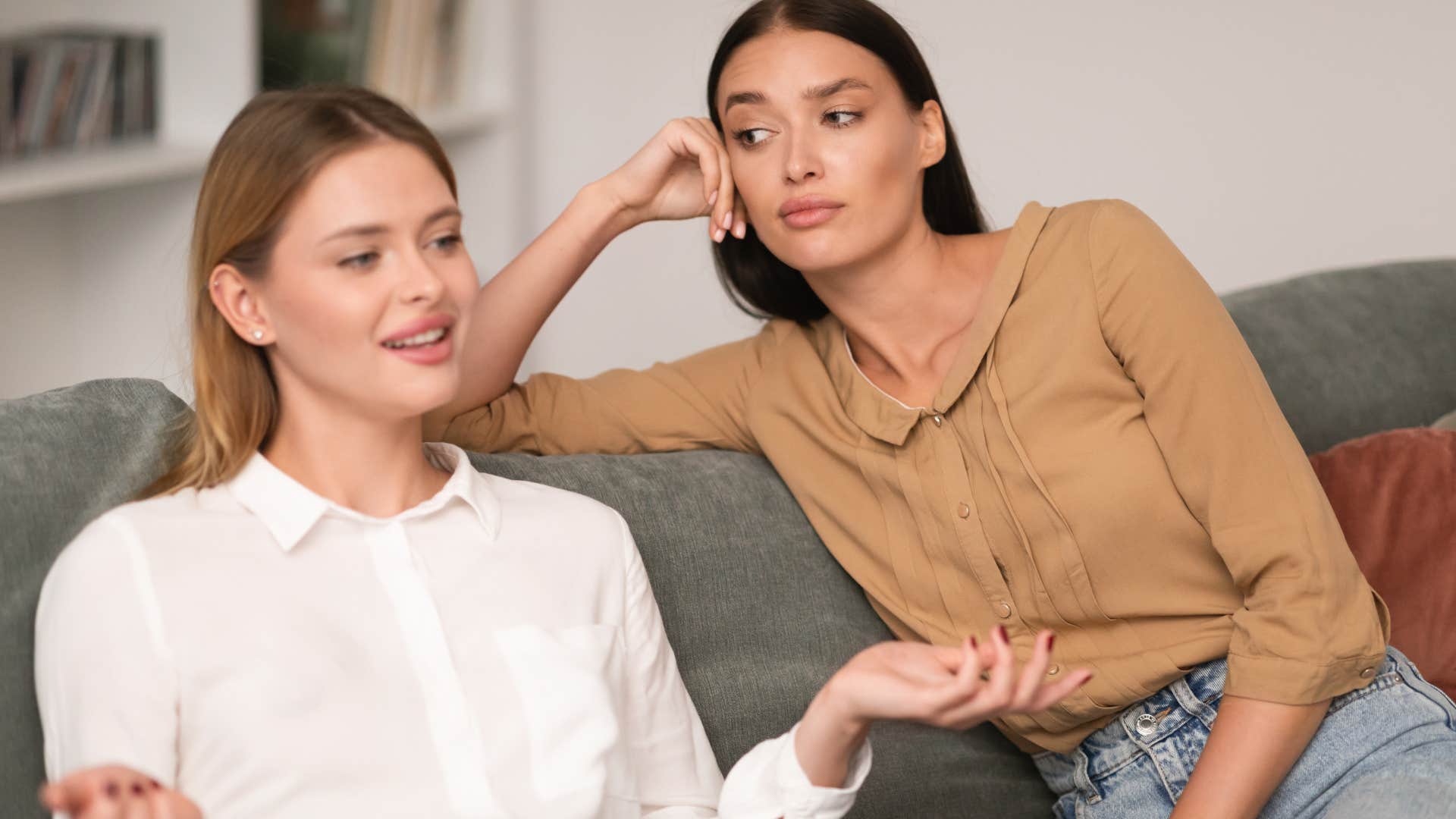 annoyed woman watching her friend talk