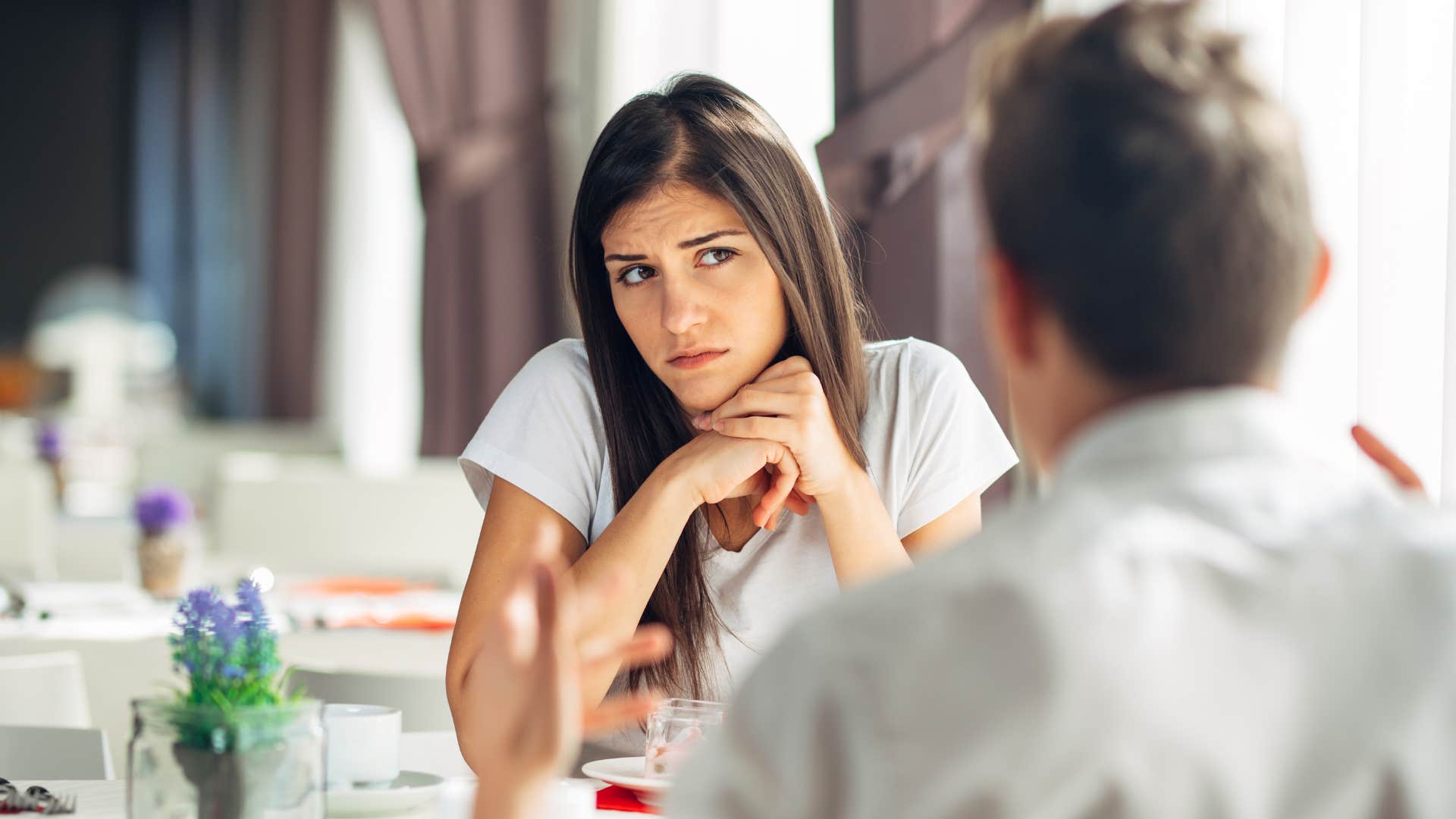 annoyed woman talking to her partner at dinner