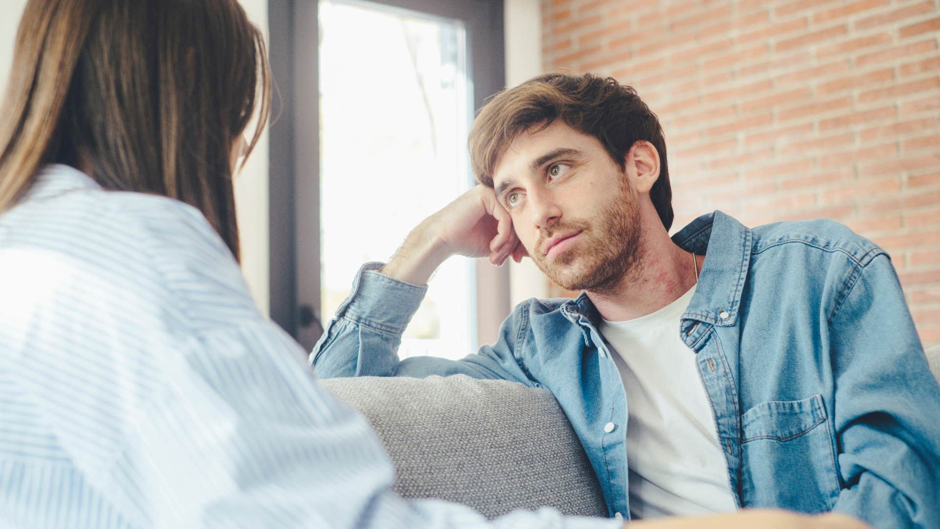 Man looking annoyed listening to his partner speak.